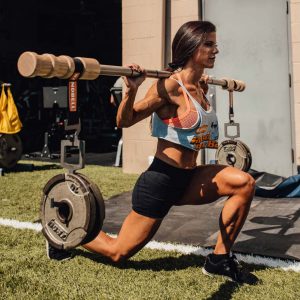 woman lunging with weight on earthquake bar